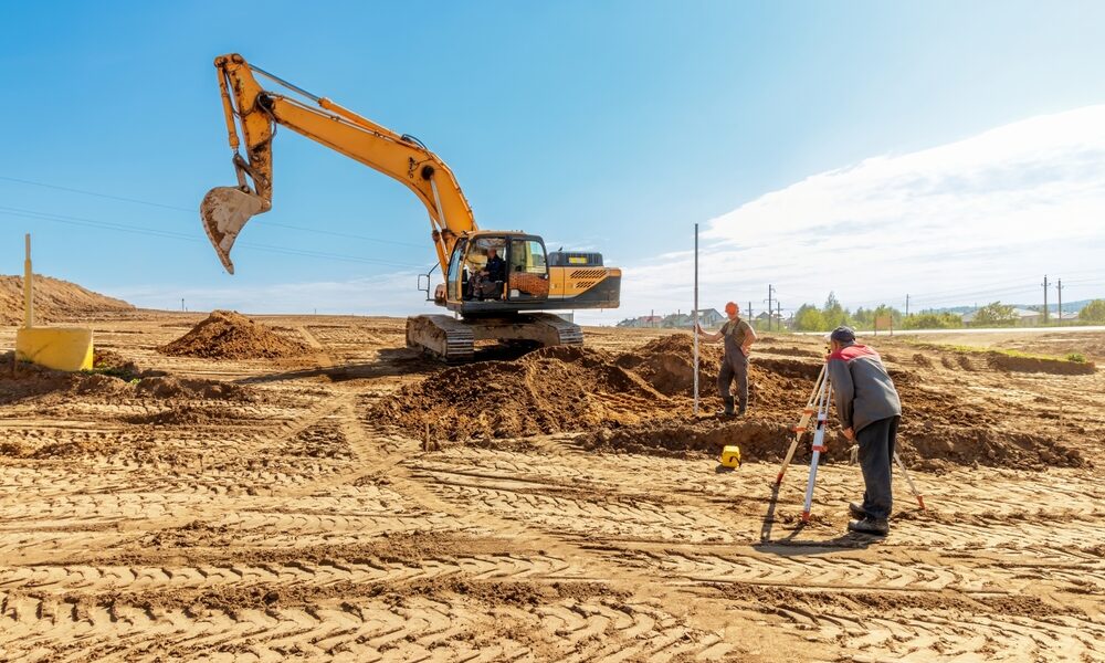 Construction,Workers,Performing,Land,Surveying,And,Excavation,Tasks,At,A